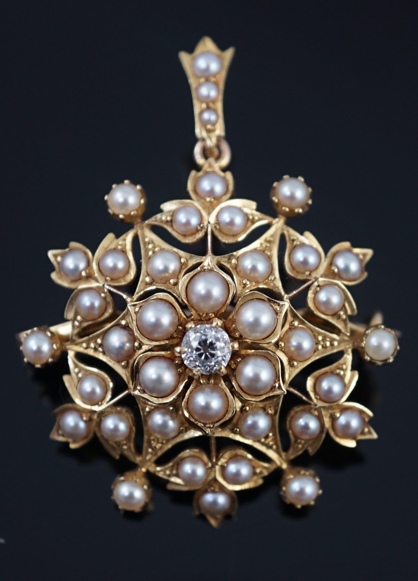 An Edwardian single stone diamond and seed pearl cluster set pendant brooch